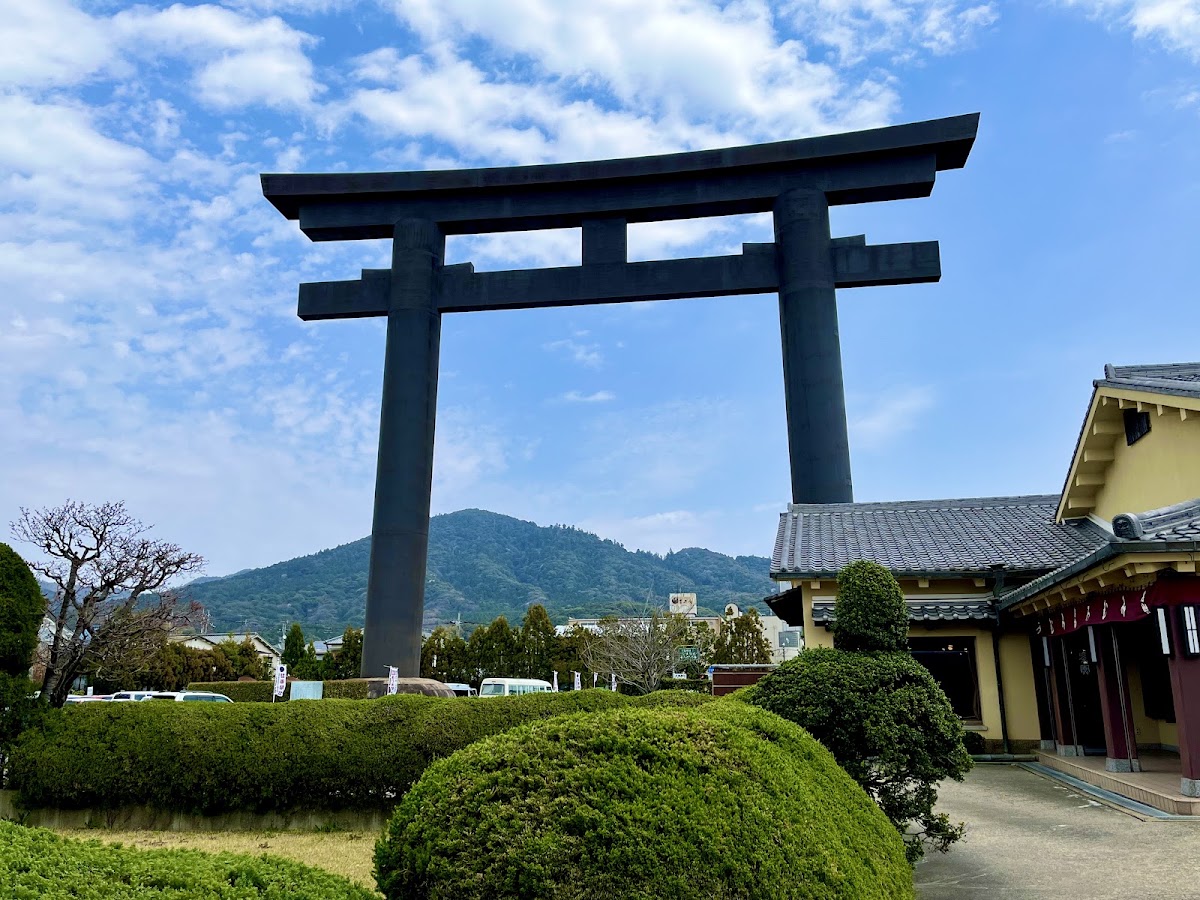 藍天下一巨大的黑色鳥居與遠山