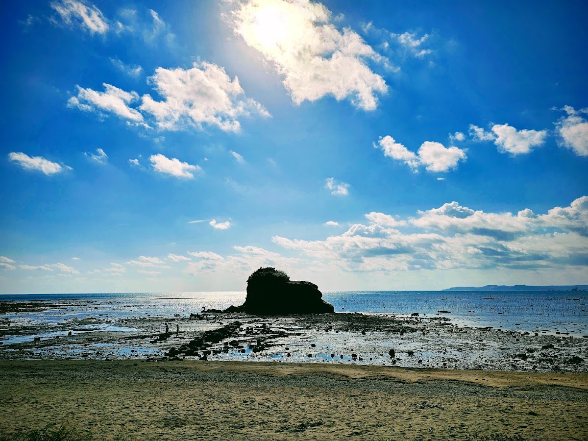 藍天白雲下的海岸沙灘與礁石