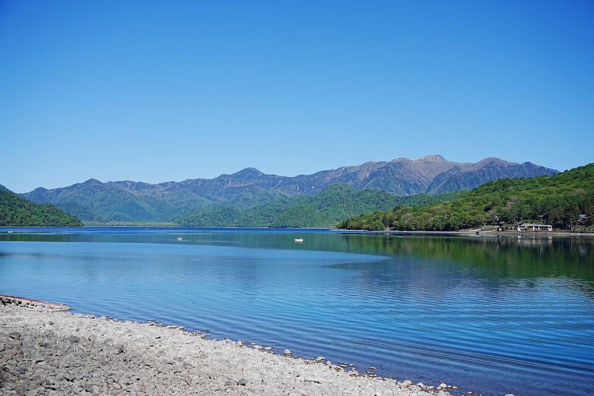 石灘岸邊的藍天湖泊風景