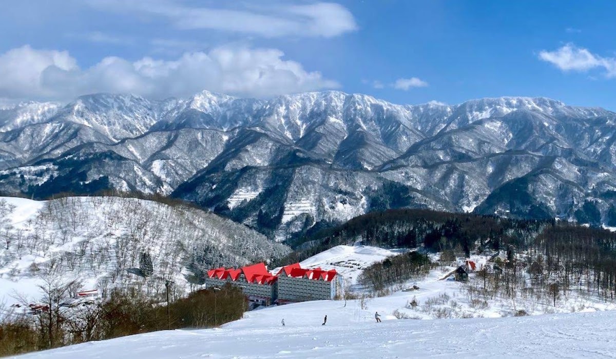 藍天白雲下的雪山與飯店大景