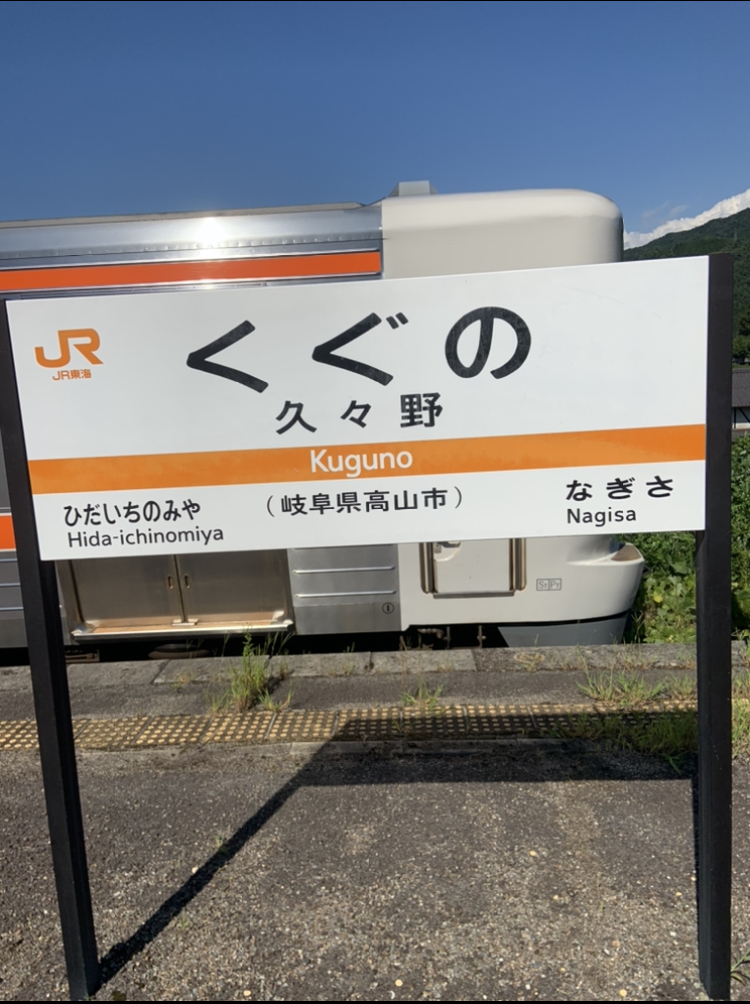 晴空下月台站名牌與列車