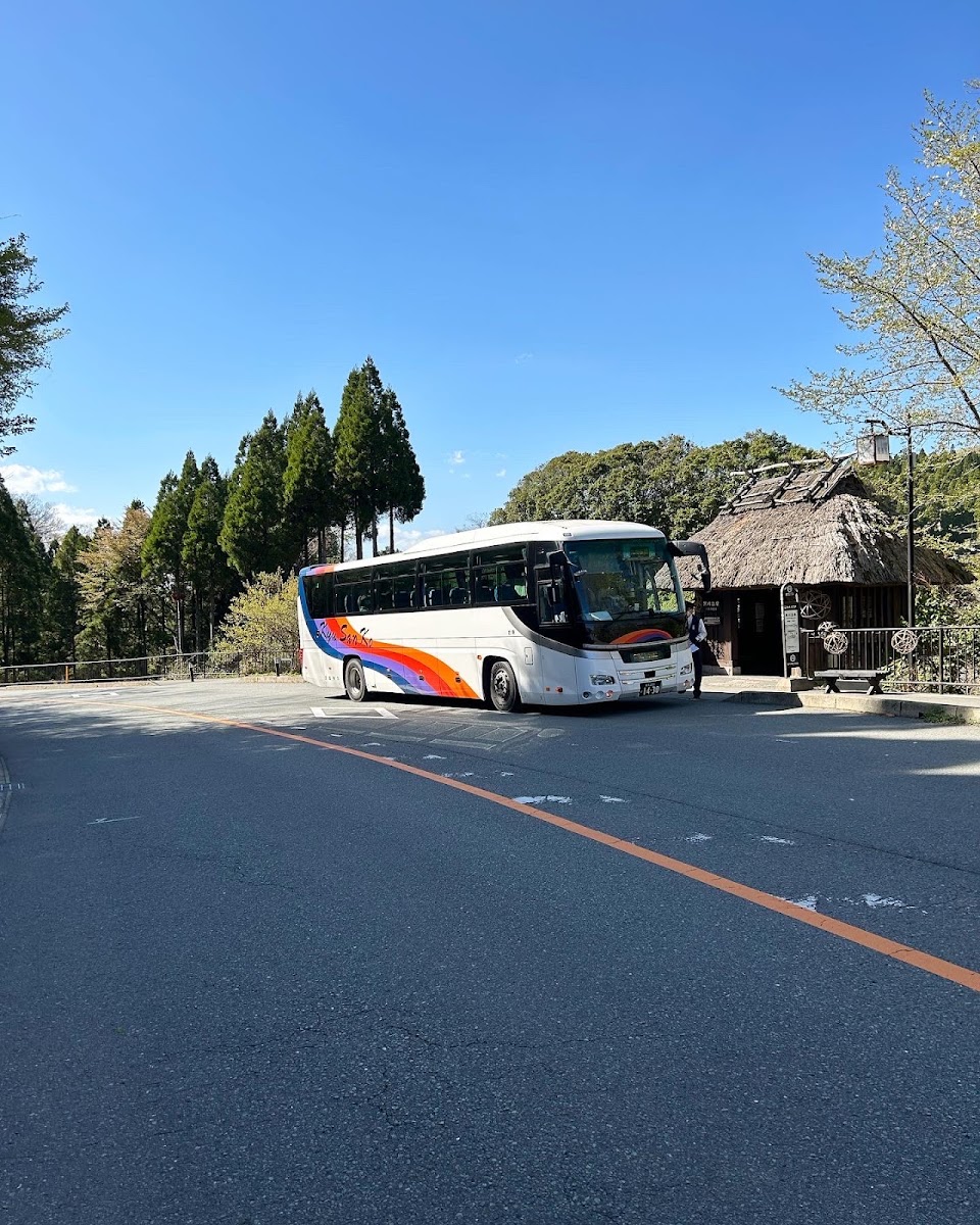 晴空下黑川溫泉公車站與停靠的巴士