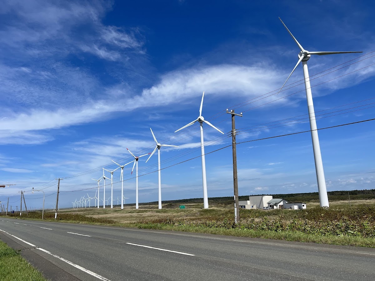 藍天白雲下的道路與風力發電機群