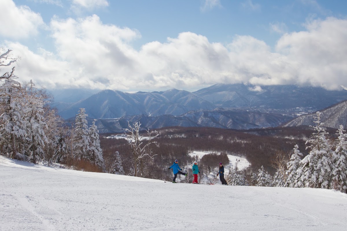 雪山頂峰與滑雪遊客的大景