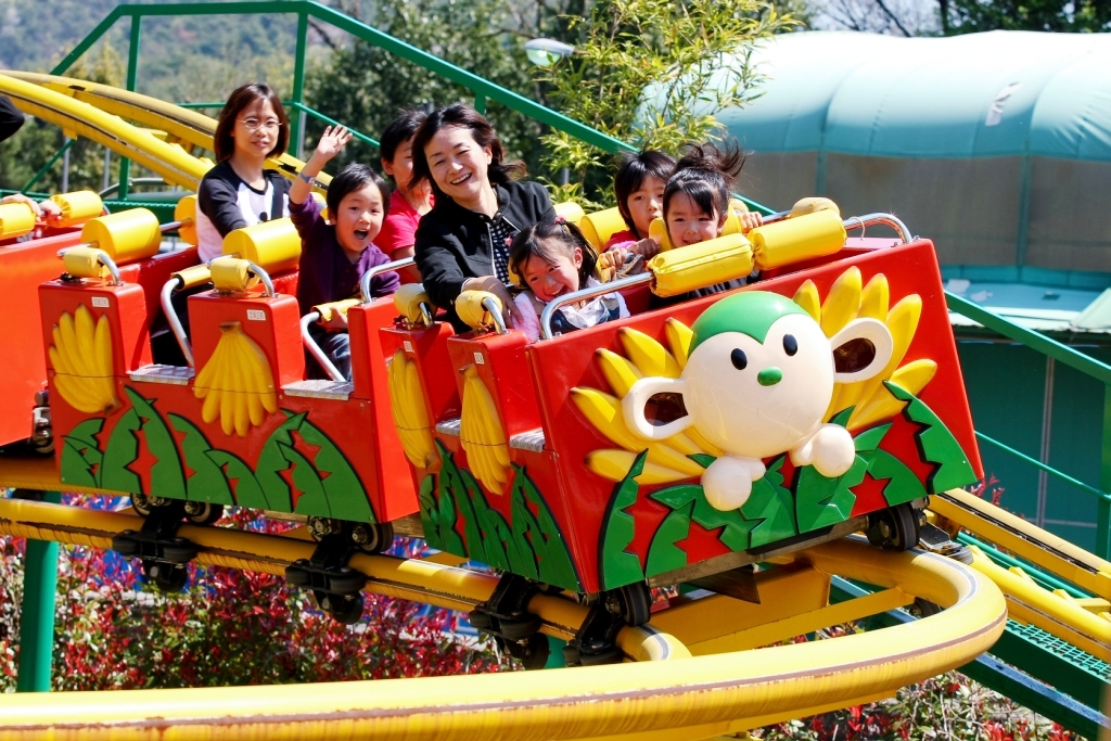 遊樂園內開心搭乘雲霄飛車的遊客