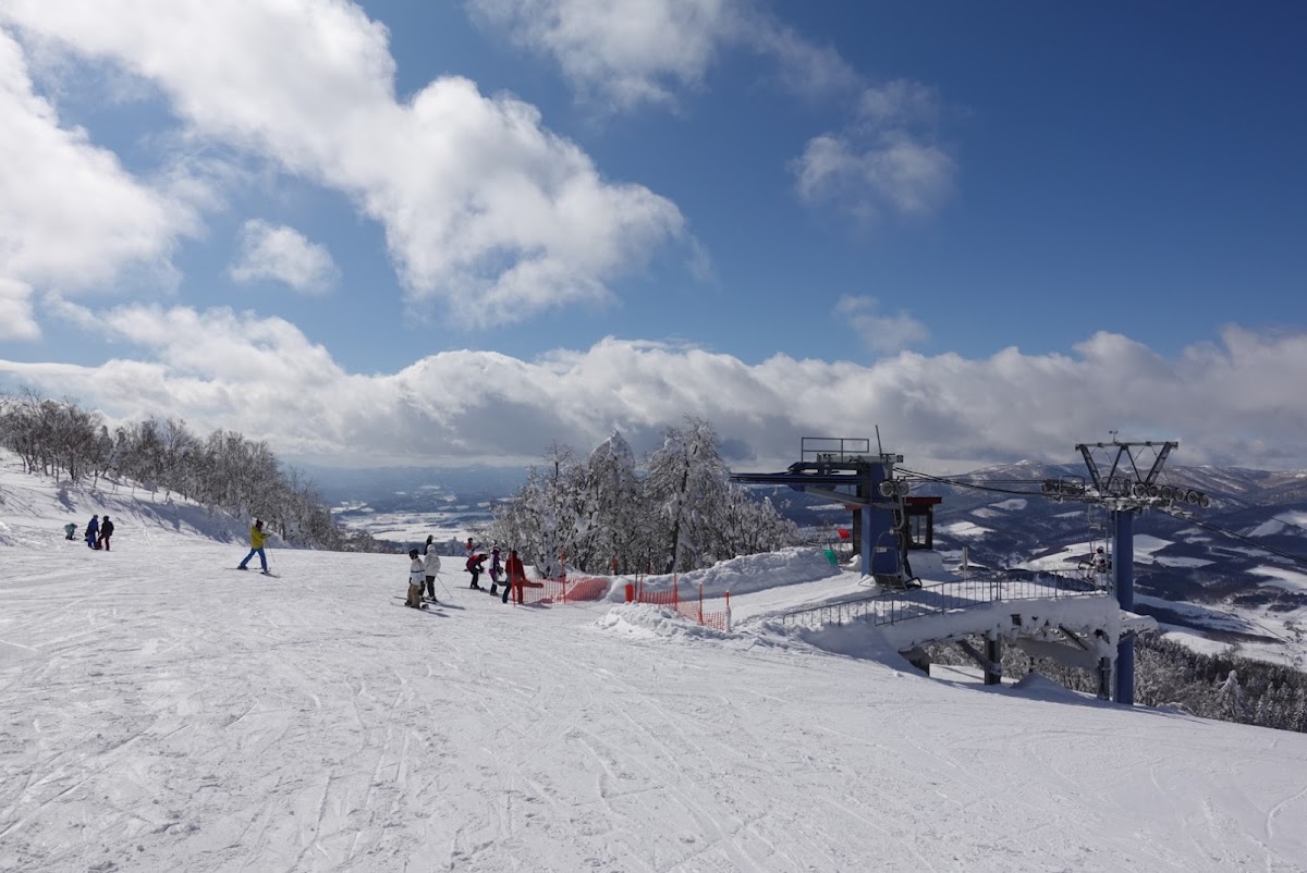 晴朗藍天下的雪場山頂與纜車站