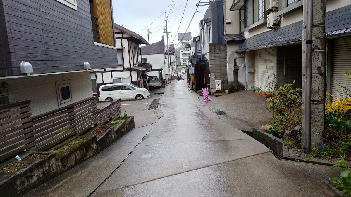 濕潤的溫泉街巷與遠處車輛