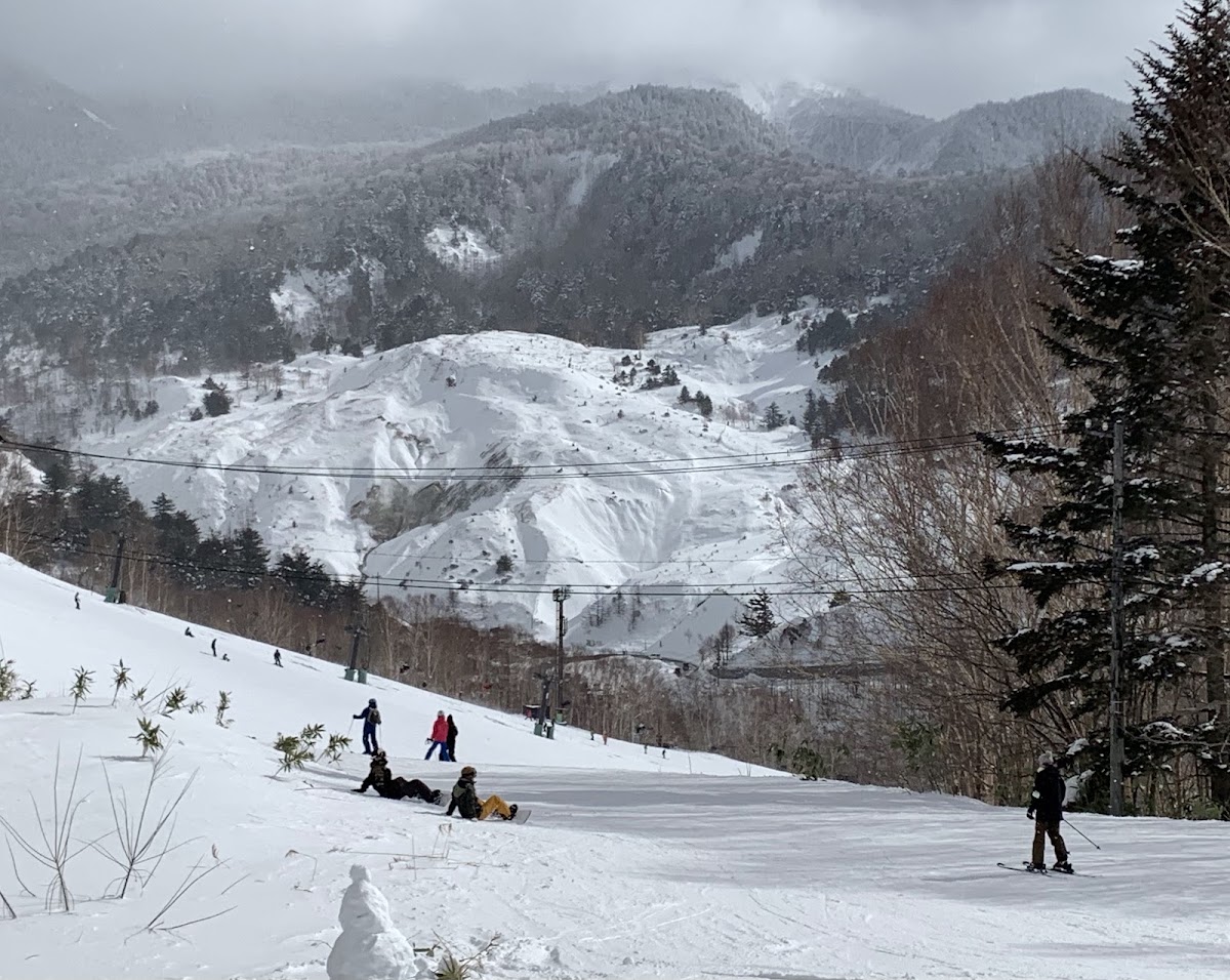 雪道上滑雪的人潮與遠山