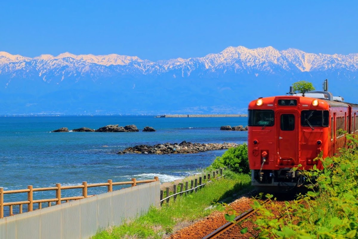 晴空下雪山與海岸列車
